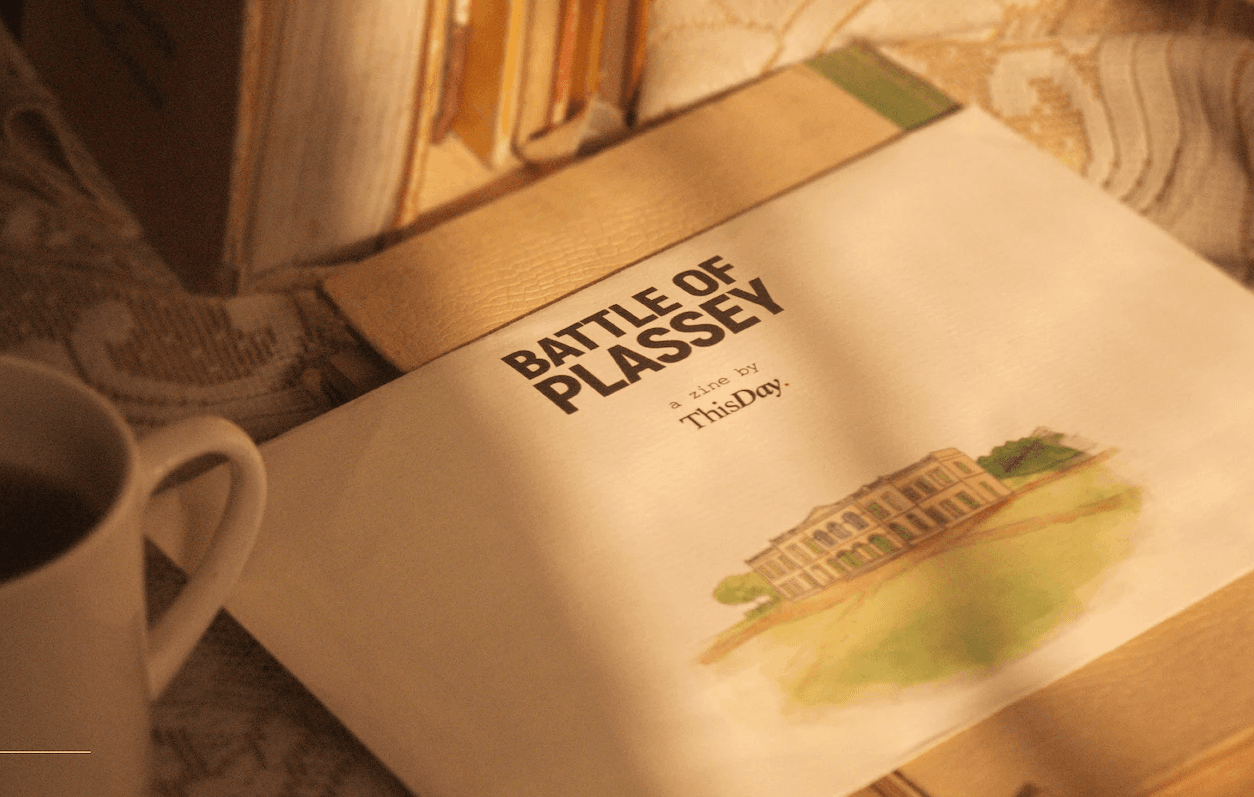 Battle of Plassey zine by ThisDay lying on a table beside a coffee mug in warm afternoon light