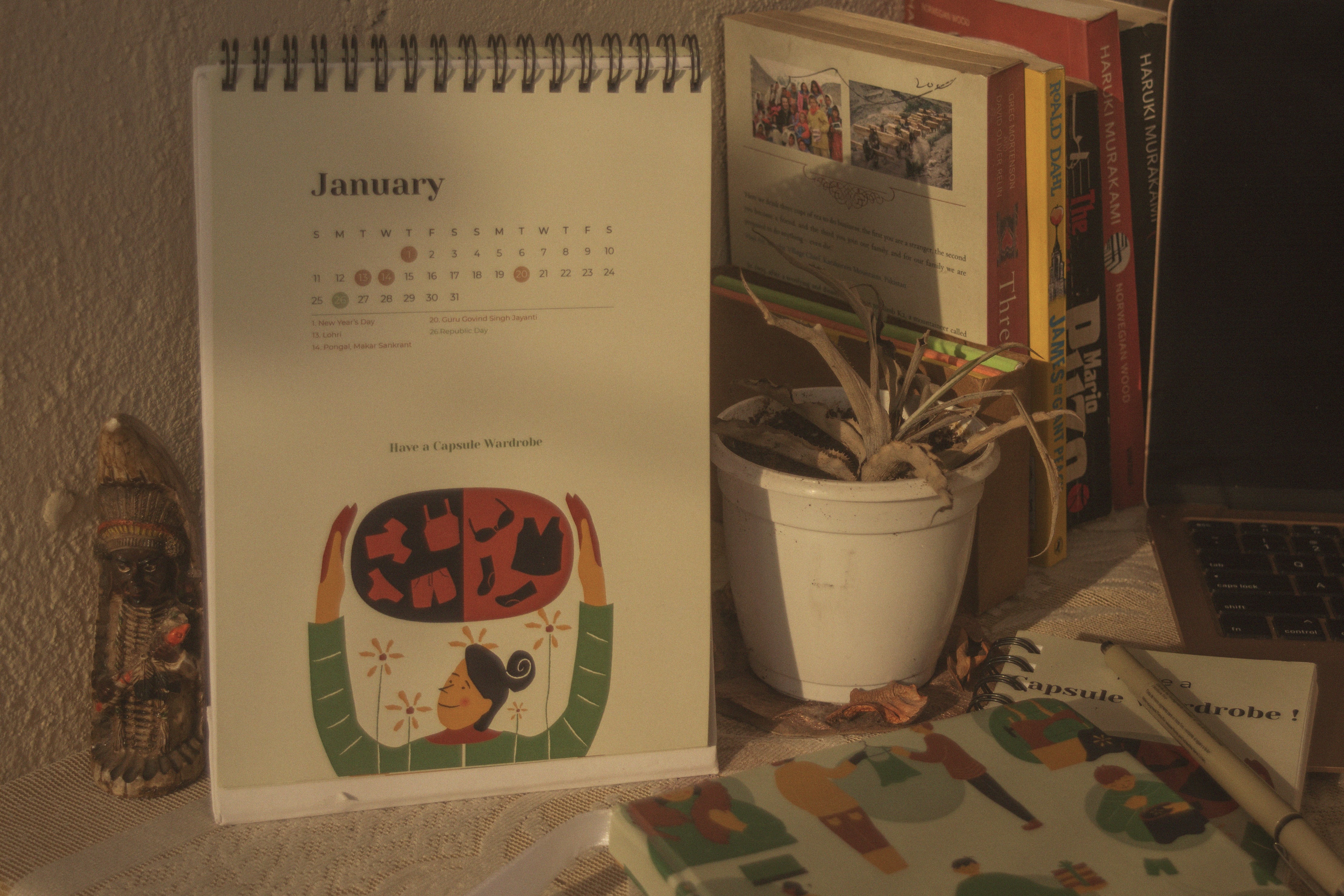 The Year Project 2021 desk calendar with an illustration of a woman holding a heart full of clothes, on a cosy desk